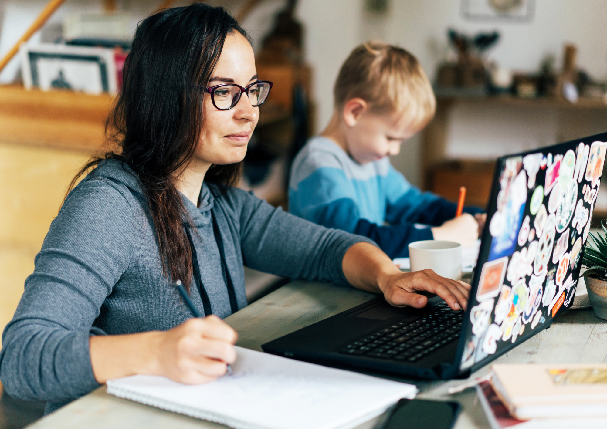 Mutter am Laptop bereitet den Wiedereinstieg nach der Elternzeit vor